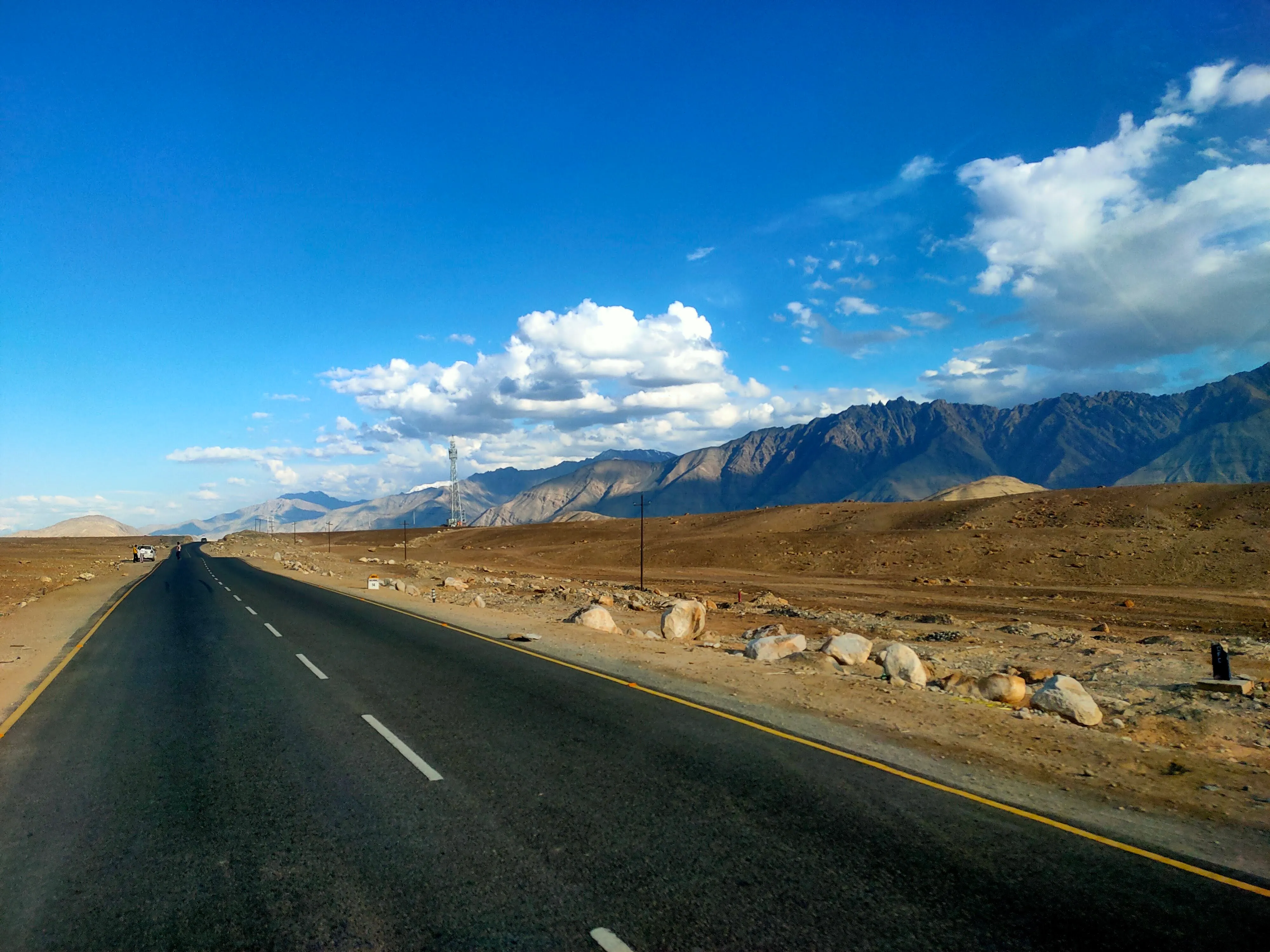 A straight highway cutting through a high-altitude desert landscape