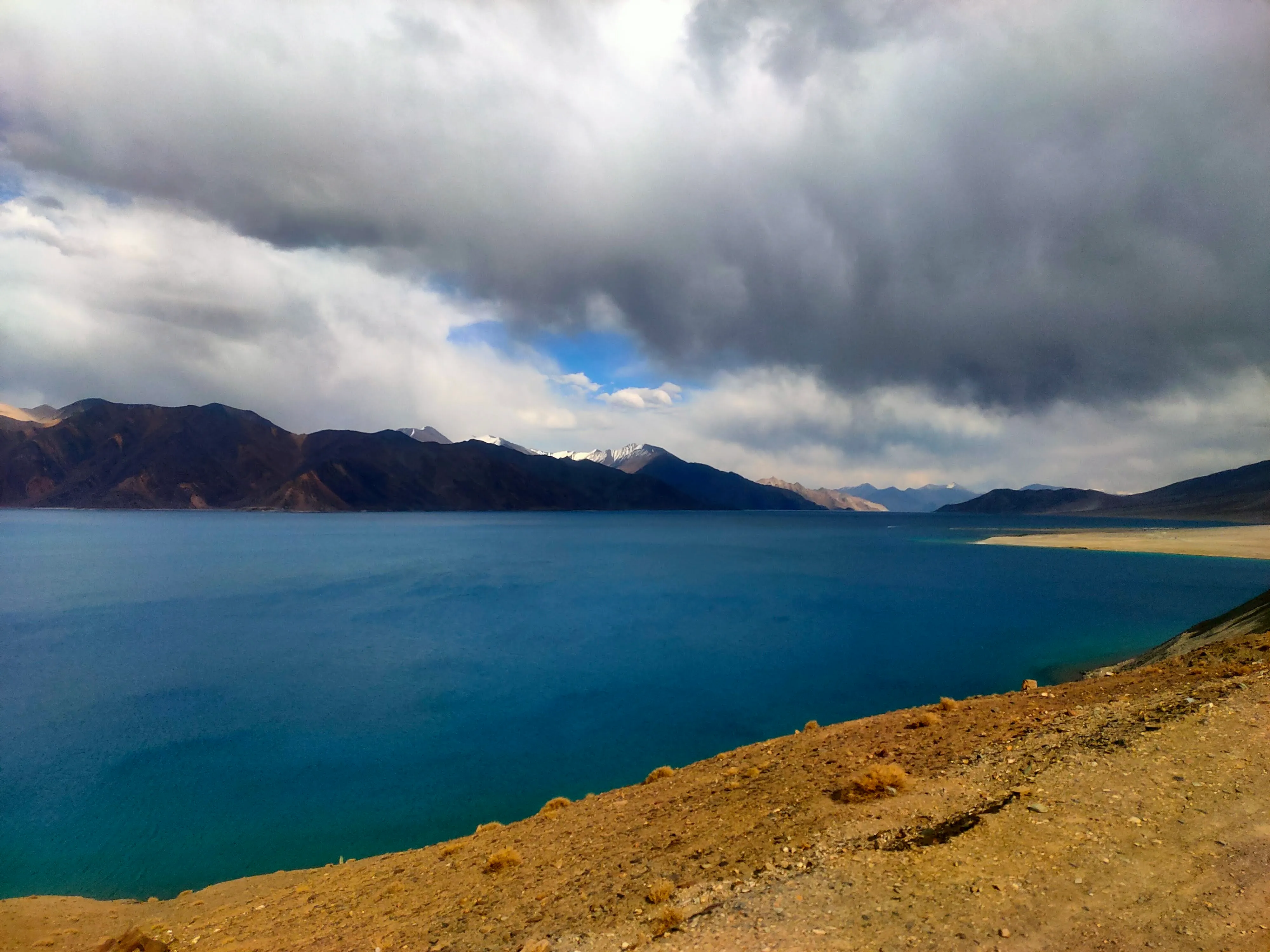 A deep blue high-altitude lake surrounded by rugged mountains