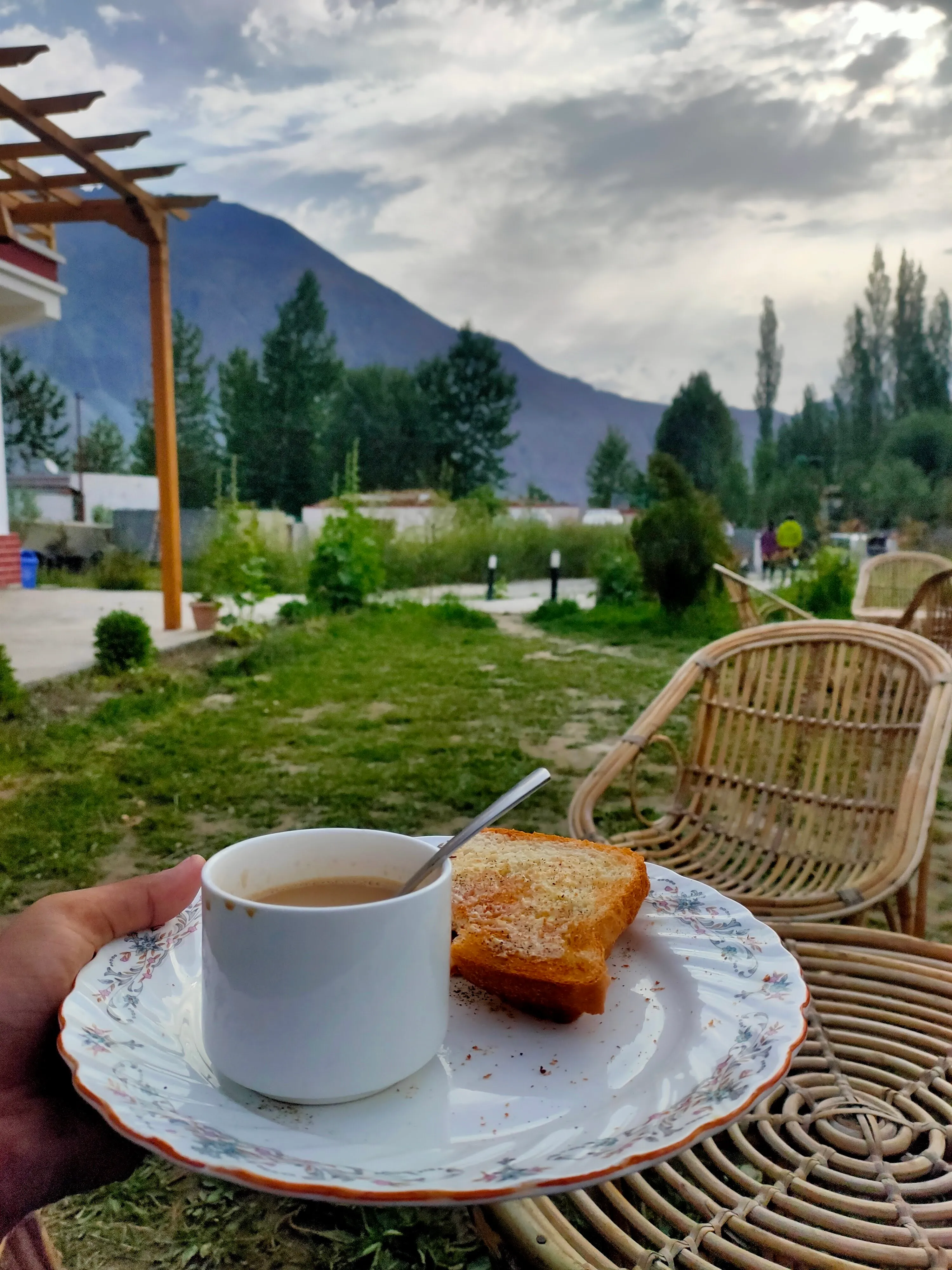 Breakfast of tea and toast on a plate with mountains in the background
